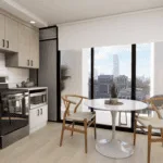 A kitchen featuring a table and chairs, equipped with various home appliances including a sink and oven. The room has cabinetry, countertops, and a floor, all contributing to the overall interior design.