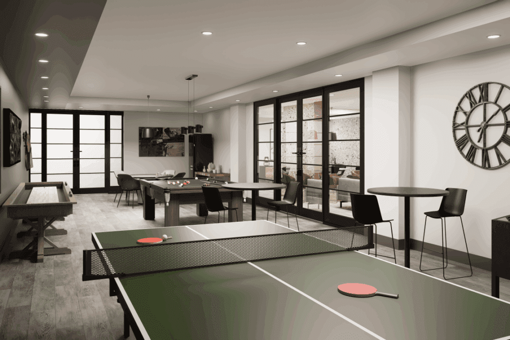 A games room featuring a ping pong table, pool table, and shuffleboard, with lots of tables and seating to play board games or poker.