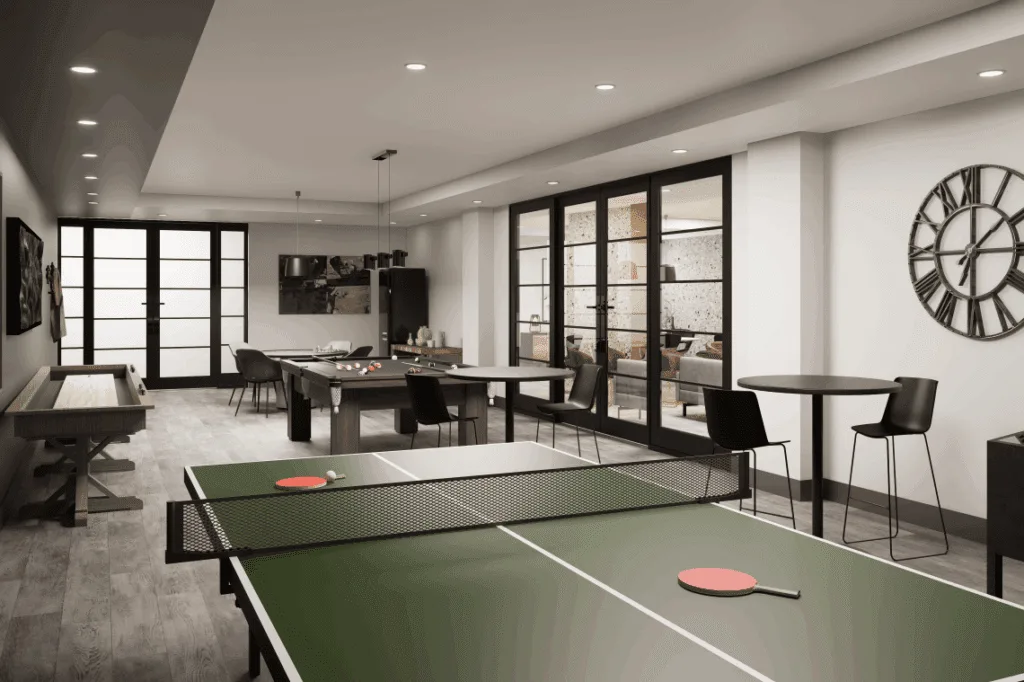A games room featuring a ping pong table, pool table, and shuffleboard, with lots of tables and seating to play board games or poker.