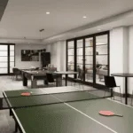 A games room featuring a ping pong table, pool table, and shuffleboard, with lots of tables and seating to play board games or poker.