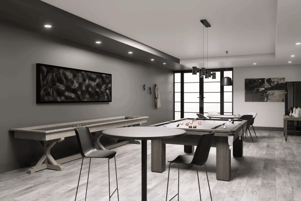 A games room featuring a ping pong table, pool table, and shuffleboard, with lots of tables and seating to play board games or poker