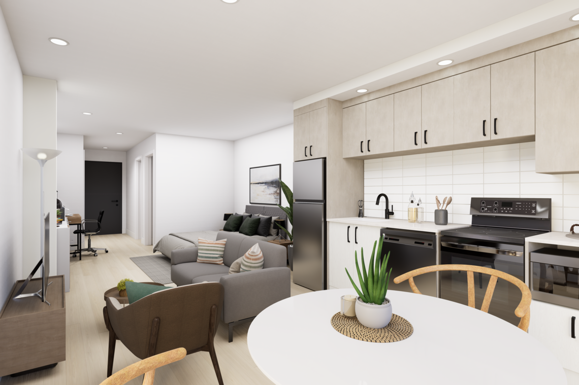 A spacious kitchen and living room area featuring a comfortable couch and a table. The interior design includes cabinetry, a vase on the coffee table, and various home appliances. The floor is well-lit, enhancing the open layout of the apartment.